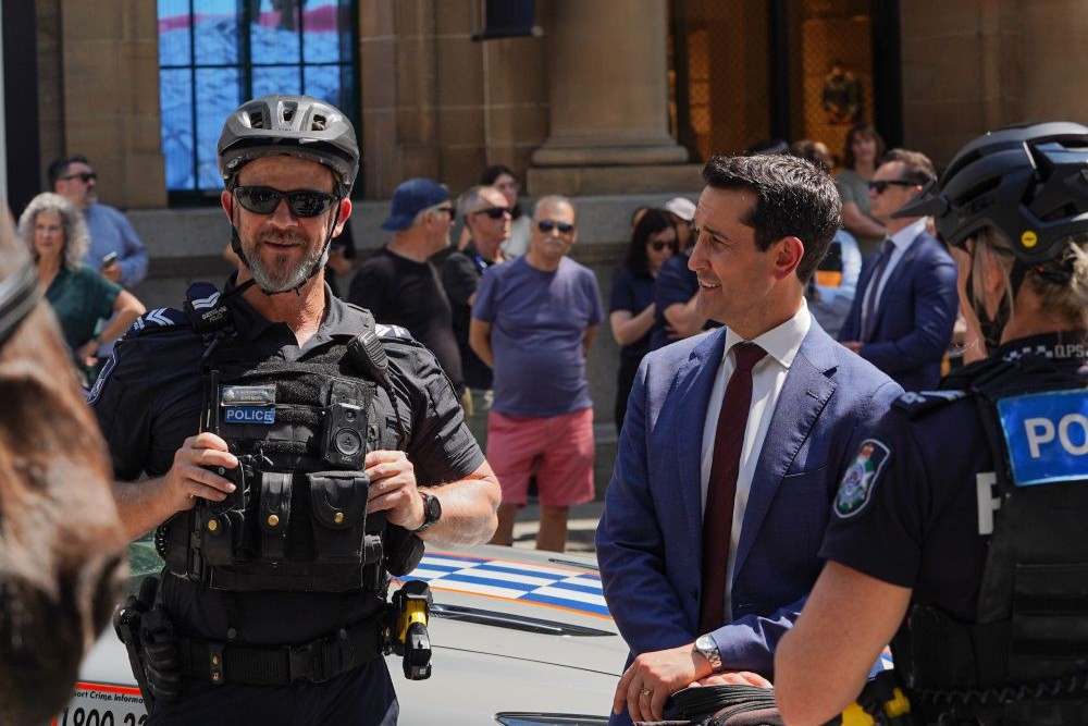 Premier with two police officers at QPS Recruitment event to announce that fewer youths have been charged under Adult Crime, Adult Time laws.